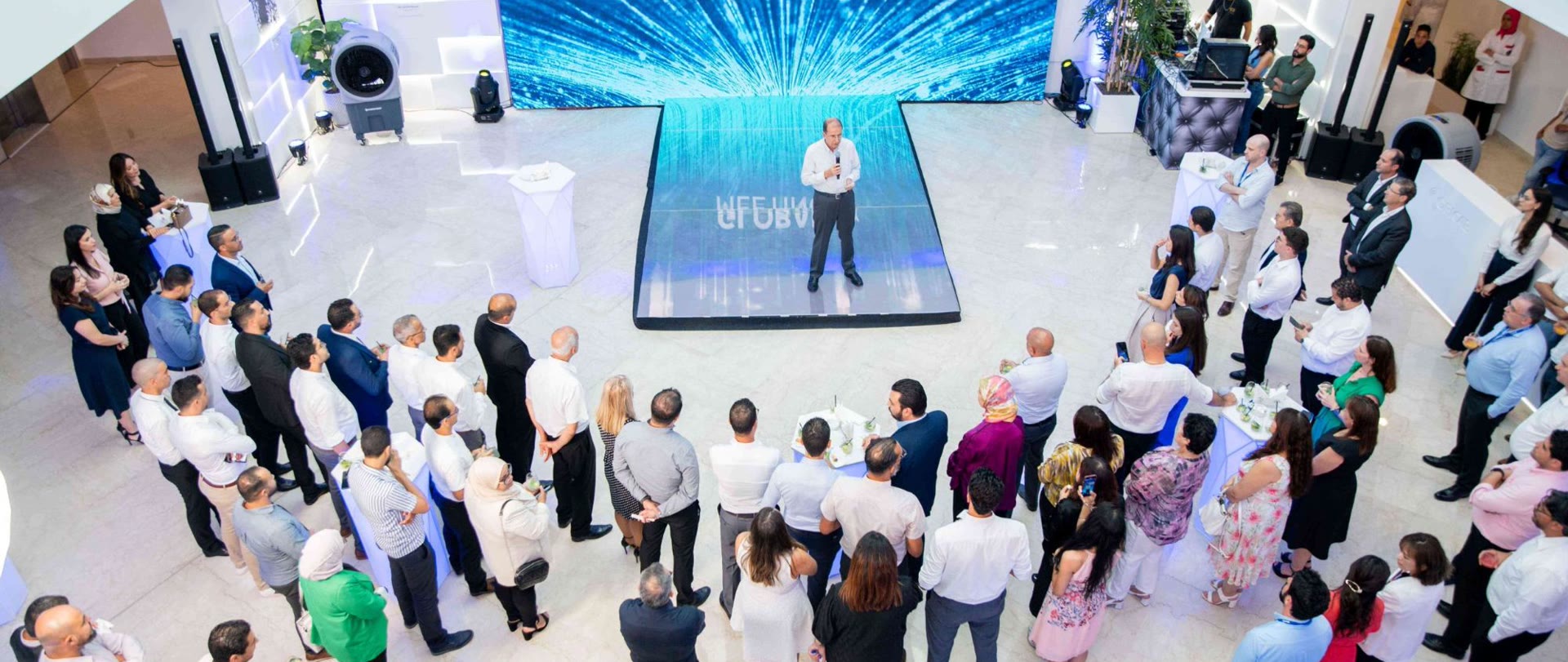 COFICAB colleagues gathered around a speaker at a company meeting