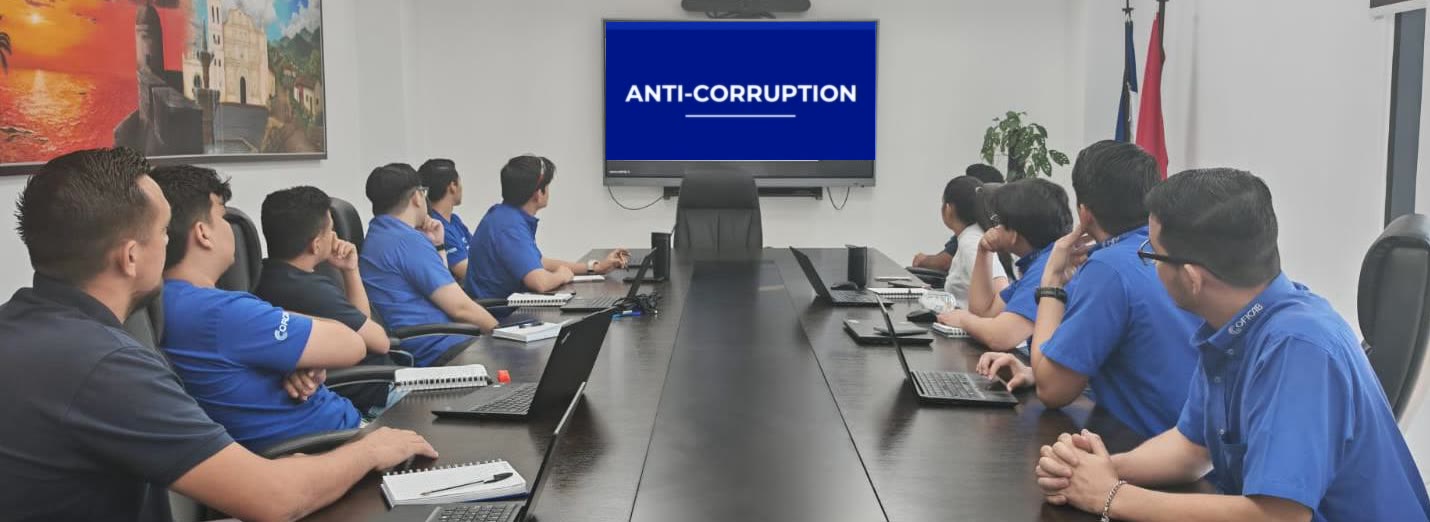 Colleagues in a meeting room watching an anti-corruption presentation